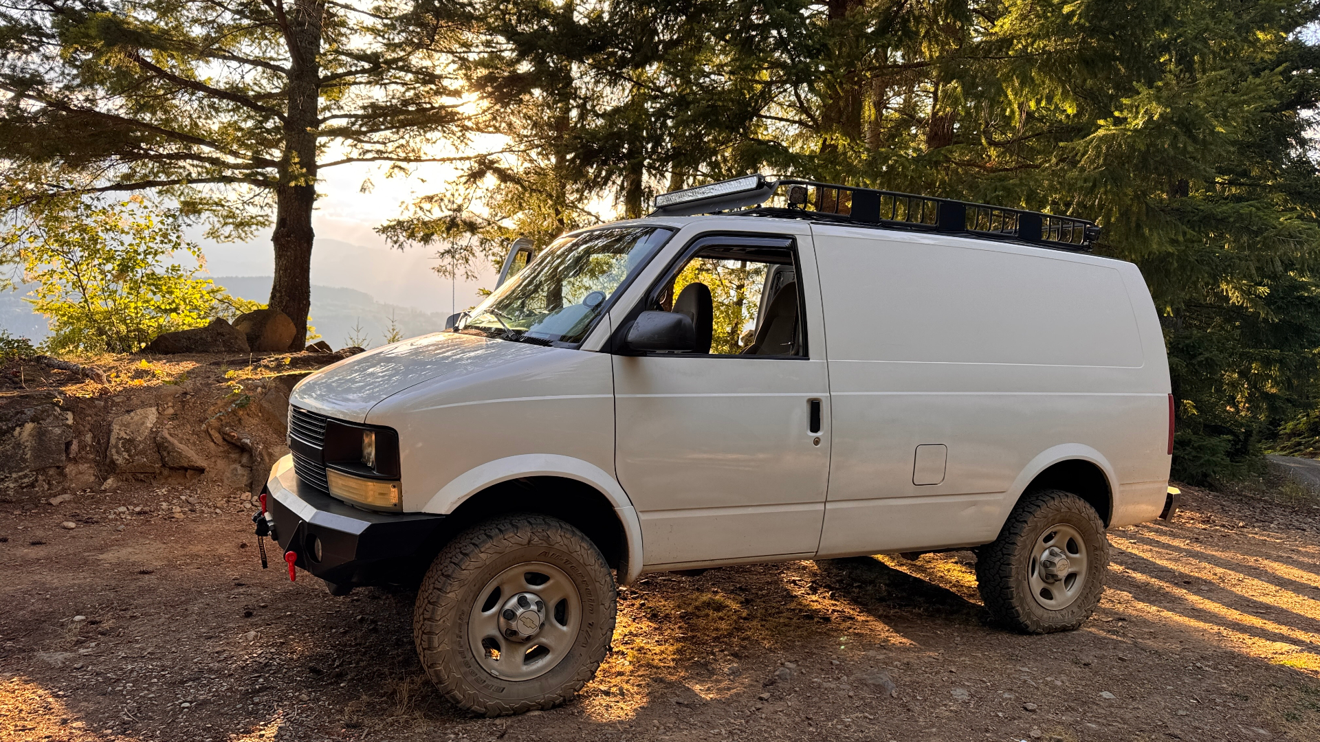 Our lifted 2005 Chevy Astro van on a forested BC backroad at golden hour